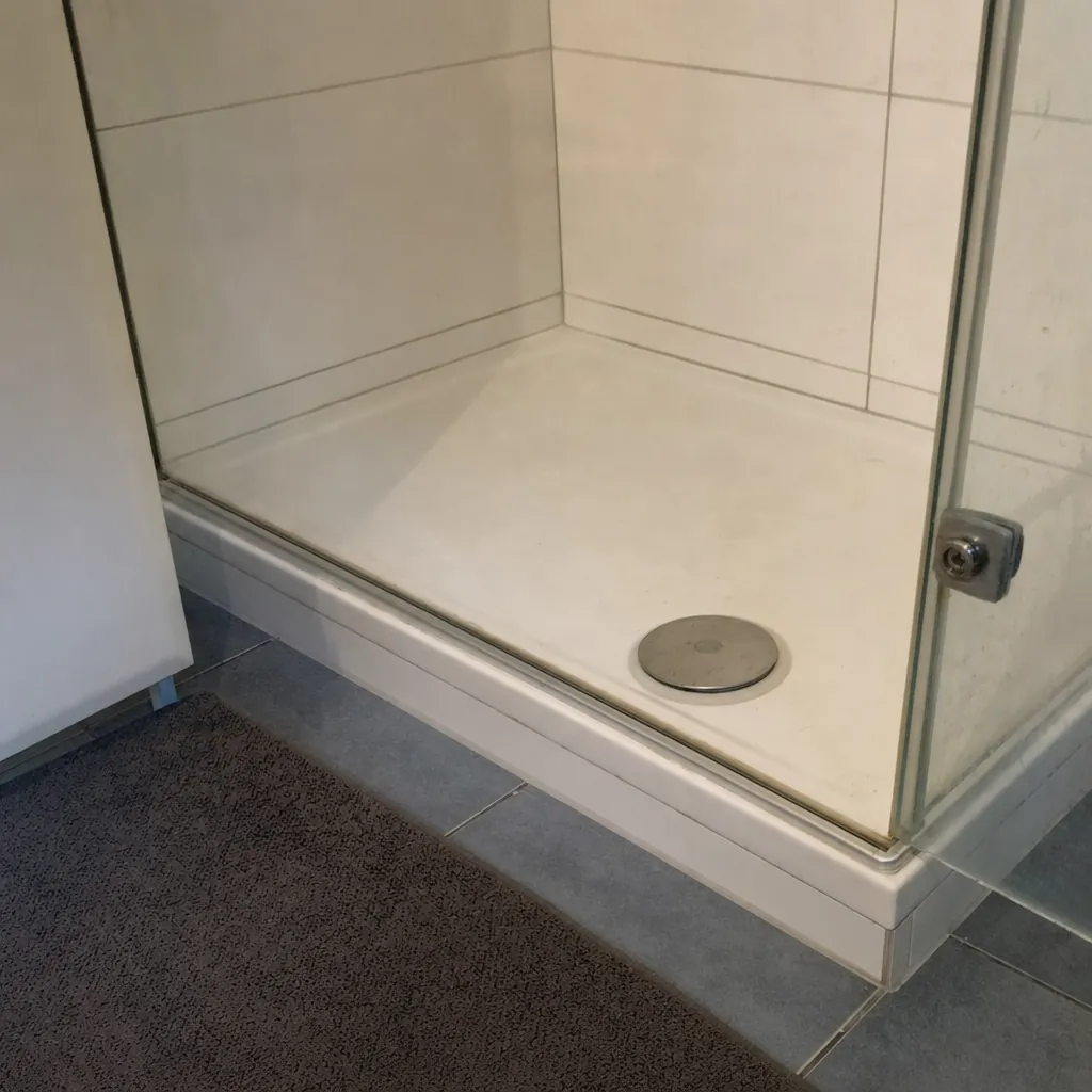 Detailaufnahme des flachen Einstiegsprofils einer Duschkabine mit Ablaufbereich (computergeneriertes Symbolbild)